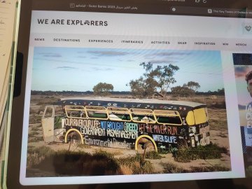 A screenshot of a website homepage titled 'WE ARE EXPLORERS' showing a featured image of a painted bus in the Australian outback.