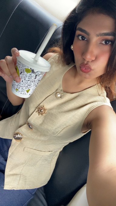 A young woman takes a selfie in a car, holding a patterned disposable cup with a straw and making a playful pout. Her cream-colored top with gold buttons and the "Boba" branded cup suggest a fun, casual treat, perfectly complementing the caption "Nagpur is treating me well."