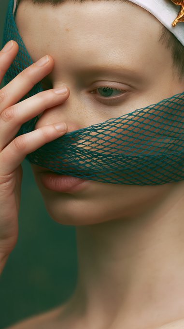 The image features a woman with short hair wearing a white headband, holding her hand over her face as if she's hiding or shielding herself from view. The background of the image is green, which contrasts with the white headband and adds depth to the scene. There are also several other elements in the image that contribute to its overall composition: 
1. A caption at the bottom of the photo reads "Hi Victoria! I have 6 editions left of 'The Inner Room' at 25 $XTZ objkt.com/tokens/KT1FZg1 ... I invite @Catherines_eyes @KazspeakArt @stripedrop". This text provides context to the image and invites viewers to engage with it by sharing their thoughts or opinions about the content of the photo.