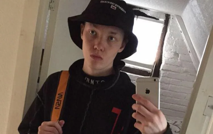 A young man in a black "Supreme" bucket hat and hoodie takes a mirror selfie with an iPhone. The post identifies him as Kai West, the British hacker who reportedly breached major institutions and evaded capture for two years by only accepting Monero, until an FBI agent convinced him to take $250 in Bitcoin.
