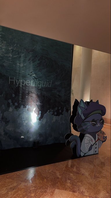 A dark display with the text 'Hyperliquid' next to a cartoon cat character in a white coat, set in a marble-floored room.