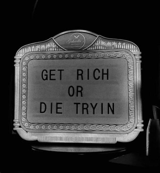 A black and white photo of a vintage-style sign reading 'GET RICH OR DIE TRYIN'' with a small 'Gabriella' emblem at the top.