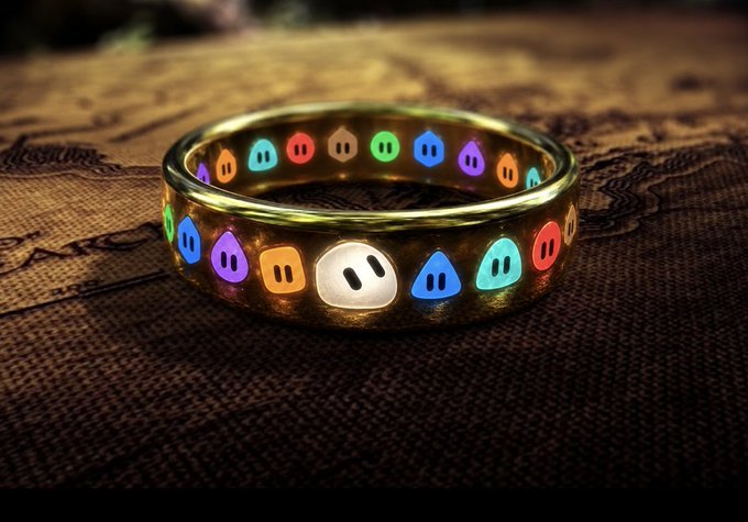 A gold band adorned with colorful glowing Geometric shapes—the icons of the Grok AI image generation app—rests on a dark map-like background, cleverly styled as "The One Ring" to symbolize how Grok Bot unifies AI creativity in a single app.
