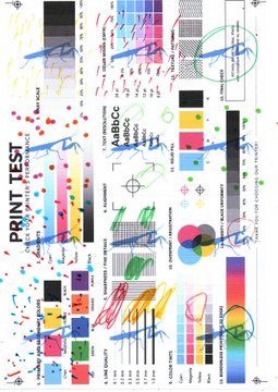 A colorful PRINT TEST calibration chart featuring CMYK color bars, registration marks, color swatches, and alignment patterns used for testing print quality and color accuracy.
