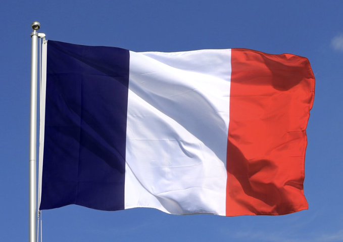 The French tricolor flag waves against a clear blue sky, symbolizing the nation at the center of a major cybersecurity breach where hackers leaked 678,000 French tax records amid a surge in crypto-related violence that has resulted in 30 physical attacks on crypto holders totaling $30 million in losses.