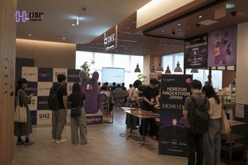 A bustling indoor event space hosts the HSK Chain Horizon Hackathon in Japan, with attendees gathered around booths displaying logos including SNZ and "HORIZON HACKATHON JAPAN DEMO DAY." The image captures the hackathon environment where AI and DeFi track winners, such as Helm, Maneki AI, and MiuroAI, were announced with USDT prizes via DoraHacks.