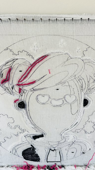 The image features a white canvas with a black and pink illustration of a person's face, which appears to be a digital art piece or a gradient design. The background of the artwork is white, providing contrast for the colorful illustration. The caption below the image reads "Working hard on this cosmic GVC" and "Making something physical from digital art is 100x tough." This suggests that creating such an intricate and detailed piece requires significant effort and skill.