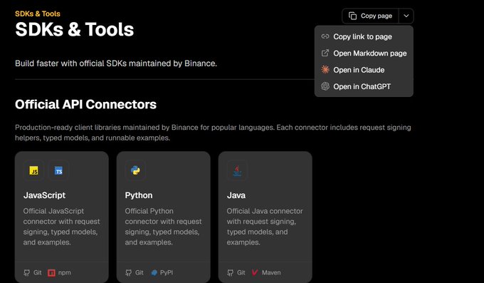 A Binance 'SDKs & Tools' documentation page showing Official API Connectors for JavaScript, Python, and Java, with a copy page dropdown menu open in the corner.