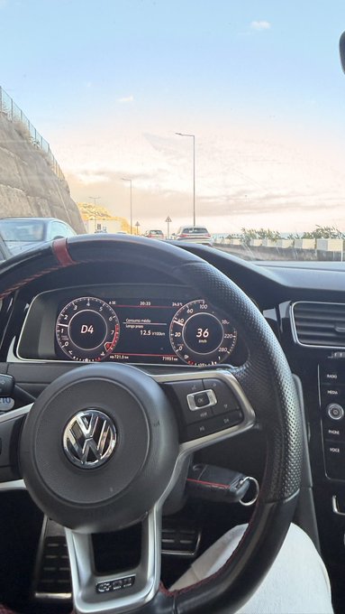 A view from inside a Volkswagen Golf GTI showing the steering wheel and digital dashboard displaying gear 'D4' and speed '36'.
