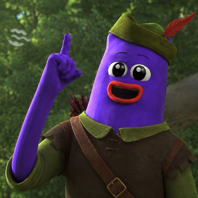 A 3D-rendered purple cylindrical character with a red mouth and large eyes, wearing a green hat with a red feather and a brown tunic with a strap, raising one finger while standing in a forest setting.