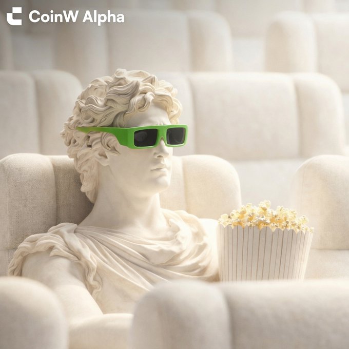 A classical marble statue wearing bright green sunglasses sits on a cream-colored couch eating popcorn, with the 'CoinW Alpha' logo in the top left corner.