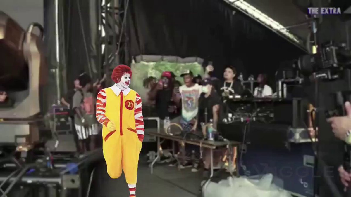 The image features a clown dressed in a red, white, and yellow outfit walking across a stage with a crowd of people behind him. The background shows a black curtain and a microphone setup for filming or recording purposes. In the corner of the image, there is a caption that reads "Bitcoin investors heading to work tomorrow down -45% from the all time highs". This suggests that the clown's appearance in the image might be related to a promotional event or campaign involving Bitcoin or cryptocurrency.