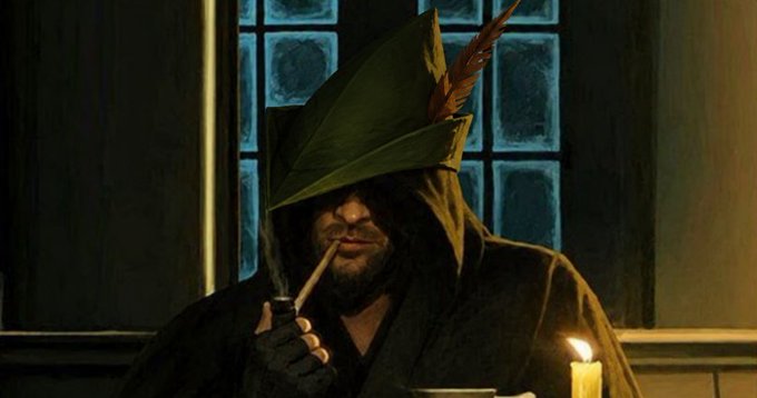 A man with a beard wearing a green, pointed hood adorned with a feather, smoking a pipe by candlelight in a dimly lit room.