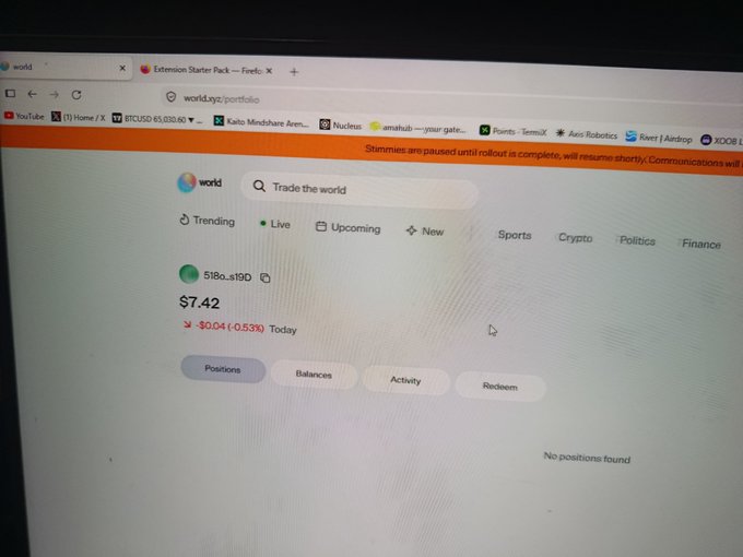 A photograph shows a computer screen displaying the 'world.xyz/portfolio' webpage for a cryptocurrency. The interface shows a balance of '5180.3190' tokens, currently priced at '$7.42', which is down '$0.04 (-0.53%) Today'.