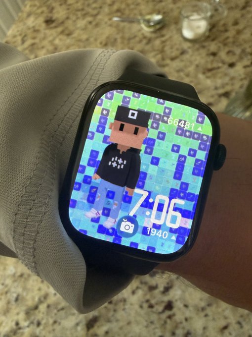 A close-up of a smartwatch on a wrist displaying a pixel-art character watch face with the time 7:06, date 1940, and step count 66481.