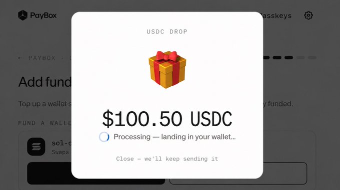 A 'USDC DROP' notification pop-up on the PayBox platform showing an incoming transfer of '$100.50 USDC' that is currently 'Processing - landing in your wallet...'.