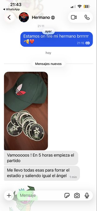 The image shows a text message conversation between two people, with one person typing out a message about their brother who is ready for an event or gathering. The other person responds by saying "Vamos a vivir en el mundo", which translates to "Let's go and have fun". The conversation takes place on a messaging app like WhatsApp, where the two individuals are discussing plans related to their brother's readiness for an upcoming event.

The image also contains several stickers scattered around it, adding a personal touch to the message.