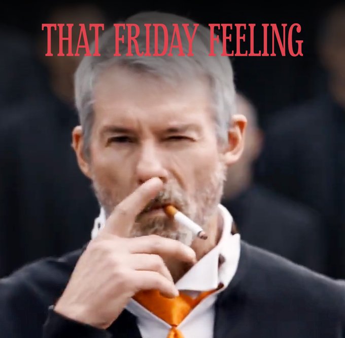 A meme image of a man in a suit smoking a cigarette with a relaxed expression, captioned 'THAT FRIDAY FEELING' in red text.