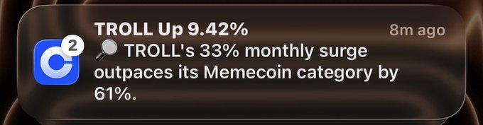 The image shows a screenshot of an iPhone screen with a message posted by someone named "coinbase" about their recent success or failure at something called Memecoin, which is a type of cryptocurrency. The message reads, "market is nuking *checks phone* positive $TROLL noti from coinbase yeah we’re going to billions regardless of market conditions". This post seems to be discussing the performance of a particular cryptocurrency or the overall market sentiment surrounding Memecoin.