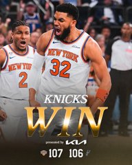 The image features two basketball players from the New York Knicks team celebrating a win during a game. The player on the left has his mouth open wide with excitement while the player on the right stands next to him, both of them wearing their jerseys proudly. In the background, there are other players and fans present at the event.
