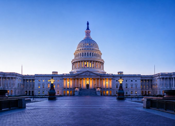 The U.S. Capitol Building illuminated at dusk, symbolizing the legislative arena where the rewritten CLARITY Act—banning presidents and Congress members from issuing crypto while in office—faces a crucial Senate vote before August 7.