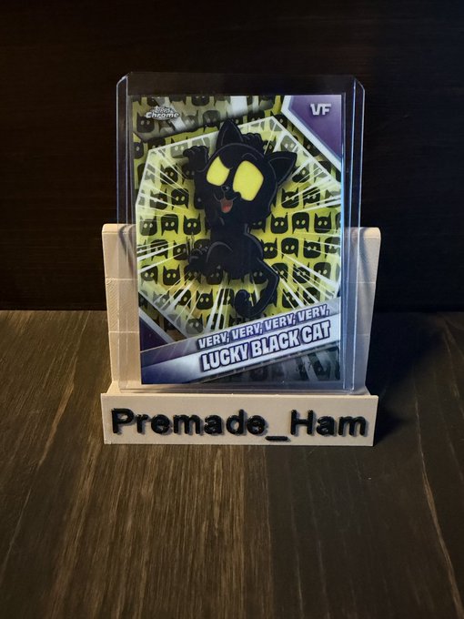 A collectible 'Lucky Black Cat' trading card displayed on a custom wooden stand labeled 'Premade_Ham,' featuring a black cat with glowing yellow eyes in a 3D-effect frame.