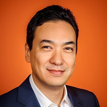 The image features a man wearing a suit, smiling at the camera against an orange background. The caption reads "OPINION: Why a Metaplanet $MPJPY and Nakamoto $NAKA merger might make sense". This suggests that the man is expressing his opinion on the matter in the image.