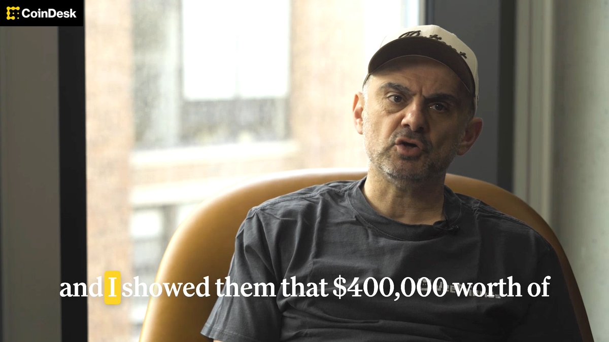 The image features a man sitting in an orange chair, wearing a baseball cap and a gray t-shirt. The background of the image shows a window overlooking a brick building. There are also some text elements in the image that include "coin desk" and "focus on what is in the image".