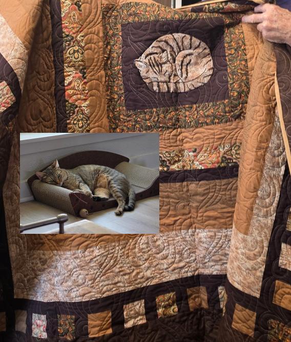 A handmade quilt featuring a custom embroidered patch of a sleeping tabby cat, overlaid with an inset photo of the real cat relaxing in a curved pet bed.