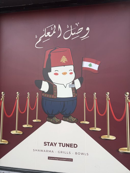 A promotional poster featuring a cute penguin mascot dressed in Lebanese traditional attire with a fez hat, holding a Lebanese flag, with Arabic text and 'STAY TUNED' branding for shawarma, grills, and bowls at bayrootdeli.com.