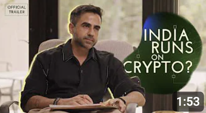 The image shows a YouTube video thumbnail or trailer featuring a man in a dark shirt seated and writing on a notepad, with bold text reading "INDIA RUNS ON CRYPTO?" and a duration of "1:53" displayed in the corner. It appears to be the official trailer for a podcast episode where the host (likely from CoinDCX based on the accompanying post) discusses India's cryptocurrency landscape with notable figures like Nikhil Kamath and Brian Armstrong of Coinbase.
