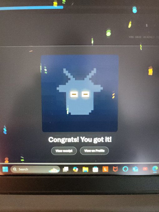 A photograph of a computer screen displaying a pixel art character with a 'Congrats! You got it!' message and buttons for 'View receipt' and 'View on Profile'.