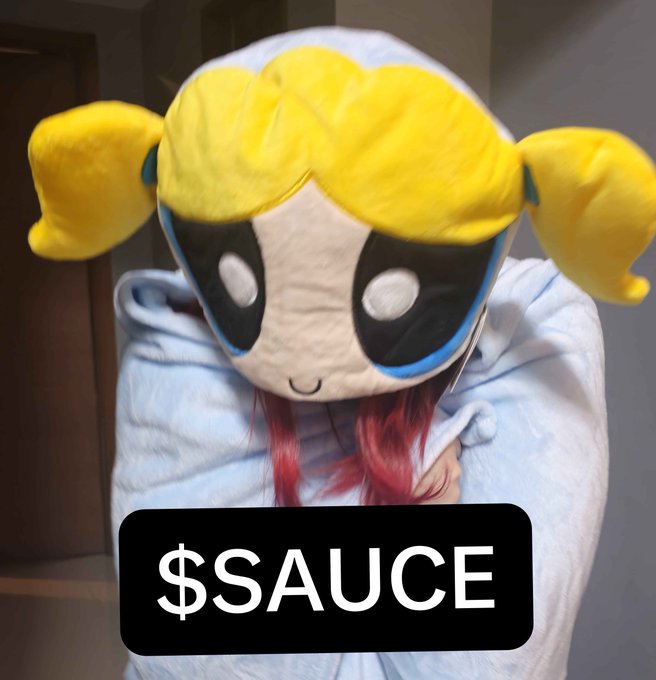 A large plush toy of Bubbles from the Powerpuff Girls with yellow pigtails, blue eyes, and a light blue dress, overlaid with a black box reading '$SAUCE'.