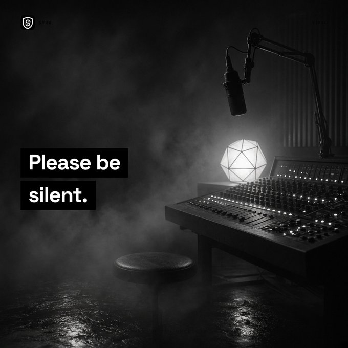 A black and white image of a recording studio with a microphone, mixing board, geometric lamp, and stool surrounded by fog. The text overlay reads 'Please be silent.' with a small logo in the upper left corner.