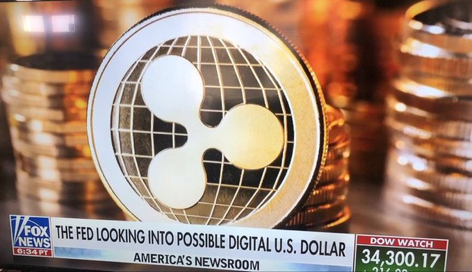 A close-up shot features the XRP cryptocurrency logo amidst stacks of coins, with a Fox News chyron reading "The Fed looking into possible digital U.S. dollar" and "Dow Watch 34,300.17." This image directly relates to $XRP and the potential for it to dominate the financial system, as suggested by the post.