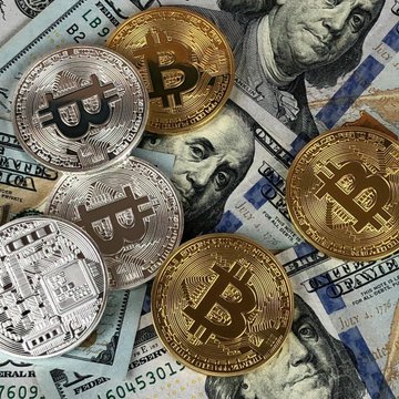 The image shows various types of currency, including a $1 bill, five quarters, gold coins (Bitcoin), and a set of US dollar bills with an intriguing caption that reads "LATEST: Bitwise says Bitcoin's fair value sits at $224K based on its sovereign default hedge model, calling BTC deeply underpriced." The focus should be on the relationship between these different denominations of currency, as well as their potential connection to Bitcoin.