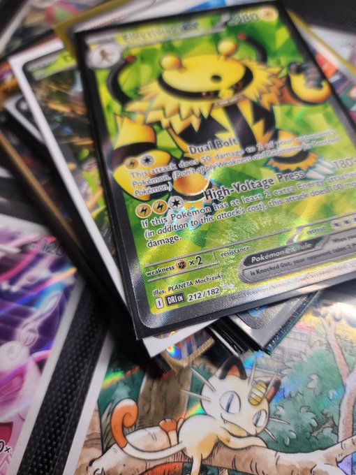 A close-up of Pokémon trading cards, prominently featuring an Electivire card with its 'Dual Bolt' and 'High-Voltage Press' attacks visible.