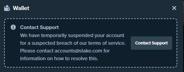 A 'Wallet' notification from Stake.com stating the account has been temporarily suspended for a suspected breach of terms of service.