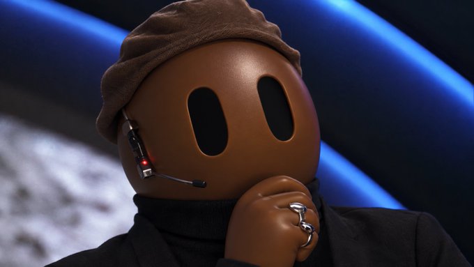A brown mascot character wearing a dark beret and headset, appearing to be on a set with blue lighting.