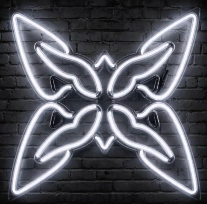 A bright white neon light fixture in a butterfly or floral shape mounted on a dark brick wall.