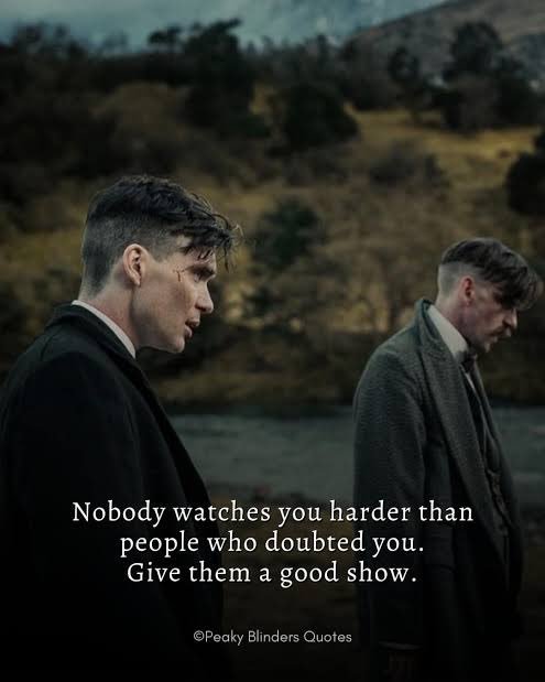 A moody outdoor scene from Peaky Blinders shows two men in suits standing near water with hills in the background, overlaid with the quote: "Nobody watches you harder than people who doubted you. Give them a good show." (©Peaky Blinders Quotes)