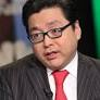 A small photo of a man wearing glasses, a dark suit, and a red tie.