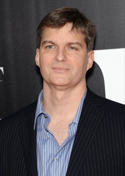 A photo of a man, presumably Michael Burry, in a black striped suit with a blue button-down shirt against a black background. The image accompanies a headline quoting Burry warning that Nvidia's $500B AI deal has "shades of Enron."