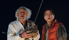 Doc Brown (Christopher Lloyd) and Marty McFly (Michael J. Fox) from Back to the Future stare in shock while holding a remote control.
