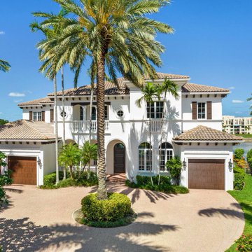 A large, two-story Mediterranean-style home with a circular driveway and towering palm tree stands under a bright blue sky, illustrating the kind of luxury property whose affordability is becoming increasingly out of reach as the average US 30-year mortgage rate climbs to a 19-month high of 7.24%.