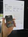 A close-up photo shows a hand holding a card or ticket in front of a document with Japanese text and the number '579' visible.