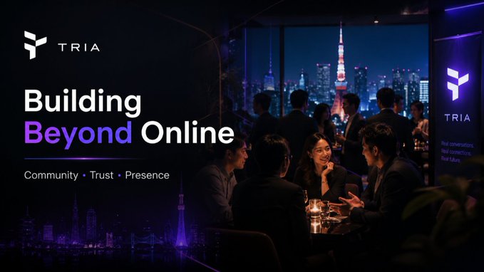 The image shows a group of people sitting around a table at a restaurant with a city skyline visible through the window. The scene appears to be set for an event or gathering, possibly related to the Tria platform. The text "Tria doesn't just build online products. @useTria is also showing up where real conversations happen." suggests that the image might be used as part of a promotional campaign or social media post about the Tria platform and its focus on building connections between people in various industries, such as crypto trading.