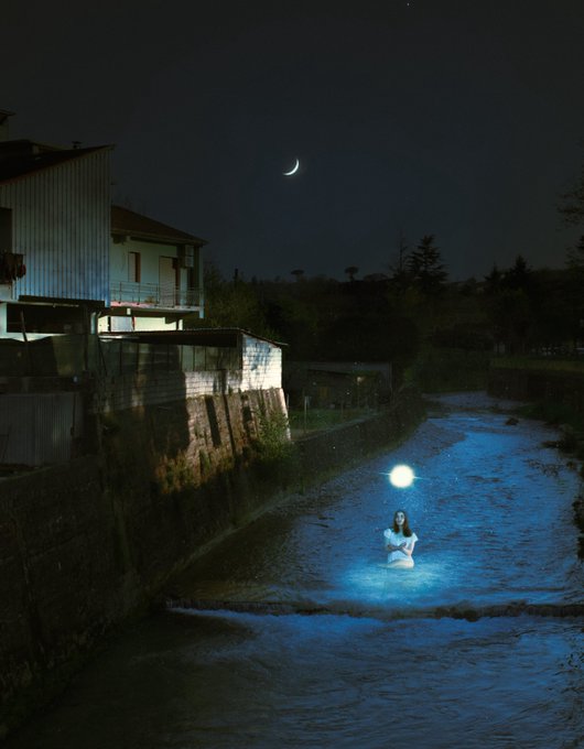 The image shows a woman standing in water at night, with a moonlit background. The photo has been edited to include a caption that reads "good morning the auction for 'Lunar' will be live for 3 more hours only! current bid 0.05 eth below to bid ↓". This suggests that there is an ongoing auction or event related to the celestial theme, and the woman's presence in the water adds a unique element to the scene.