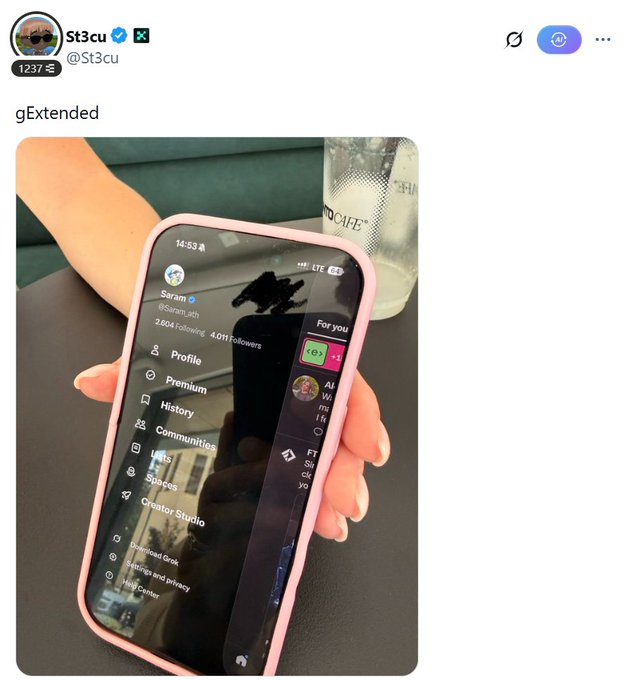 A hand holds a pink-cased phone displaying the X (formerly Twitter) profile sidebar menu for "Saram" (@Saram_ath), verified with 4.0M followers, showing options like Profile, Premium, History, Communities, Spaces, and Creator Studio. The post speculates about a potential collaboration between Extended and Kaito AI, with the image supporting the claim by showing what appears to be an Extended staff member's profile (@Saram_ath).
