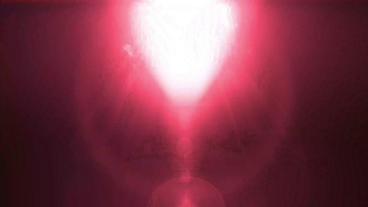 The image features a large red circle with a white center that appears to be glowing, possibly due to a lens flare effect or a camera flash. The background of the image is dark purple, which contrasts with the bright red circle. The caption below the image reads "GLM 5.2 is live on @akashnetAI".